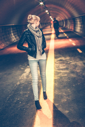 Young Woman walking Alone in the Tunnel