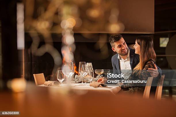 Young Couple Enjoying A Romantic Dinner Together Stock Photo - Download Image Now - Restaurant, Couple - Relationship, Fireplace