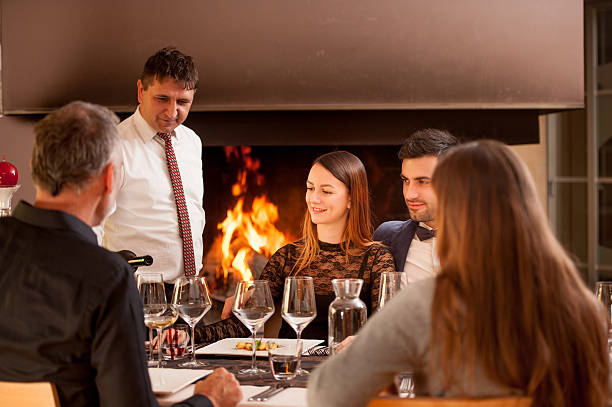 istock Waiter Serving a Group of Friends in a Restaurant 636350306