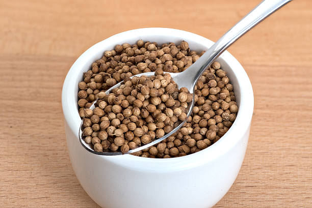 istock Coriander seeds spoon and in small white bowl 636351948