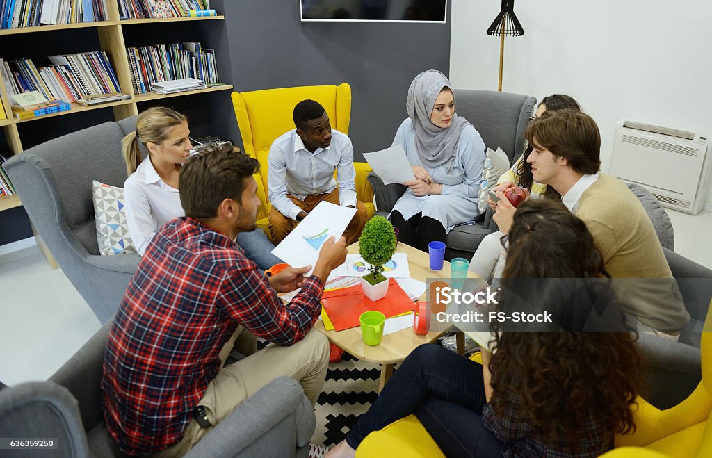Young team of freelancers searching information making business tasks consulting Young team of freelancers searching information making business tasks consulting with expert. Students preparing presentation using technology modern laptop wireless internet connection in coworking Adult Stock Photo