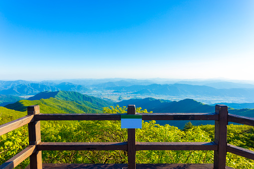 Wooden viewpoint deck offering clear view of valley below from atop Jirisan Mountain in South Korea. Horizontal