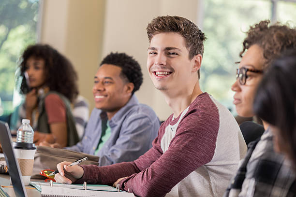 istock Confident Caucasian male college student takes notes in class 636362408