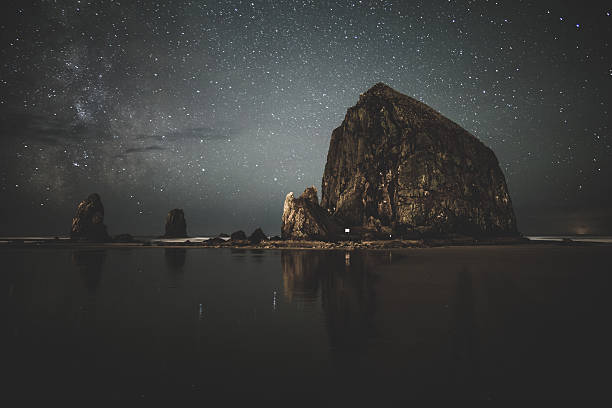 Stars and Milky Way behind Hay Stack Rock stock photo