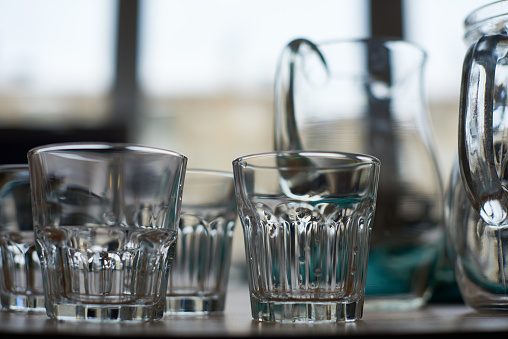 Close-up of empty drinking glasses and jugs on table