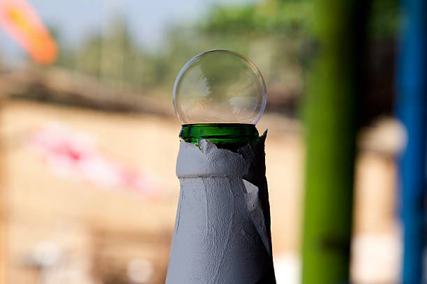 Large bubble on a bottle of beer at a beach Close up of a large bubble on a bottle of beer. Shot at the Anjuna beach in Goa, India beach goa party stock pictures, royalty-free photos & images