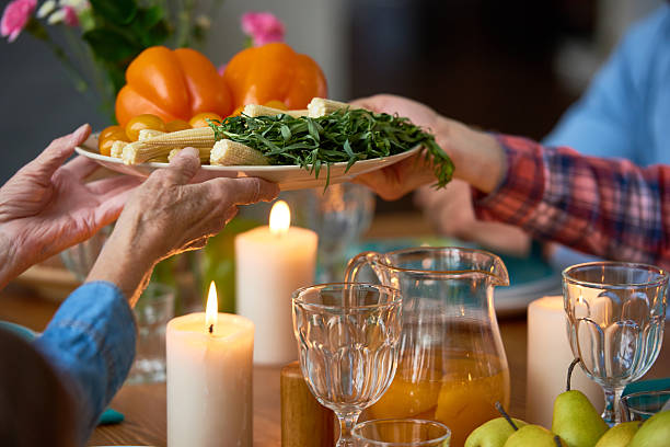 istock Senior woman passing vegetable plate to daughter 636369946