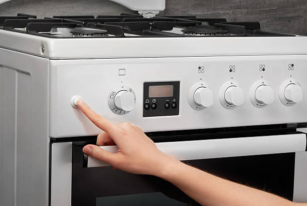 istock Female hand turning on white kitchen gas stove 636372434