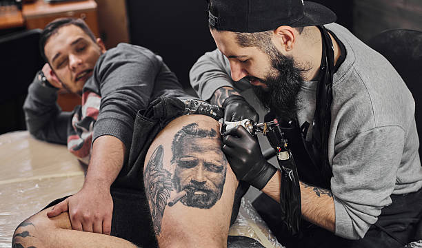 istock Tattoo master is tattooing in the tattoosalon 636372728