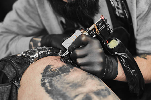 istock Tattoo master is tattooing in the tattoosalon 636372896