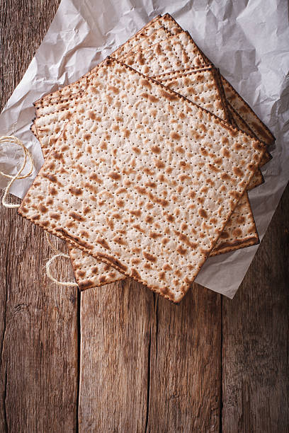 istock Jewish kosher matzah closeup on paper on a table. vertical 636372966