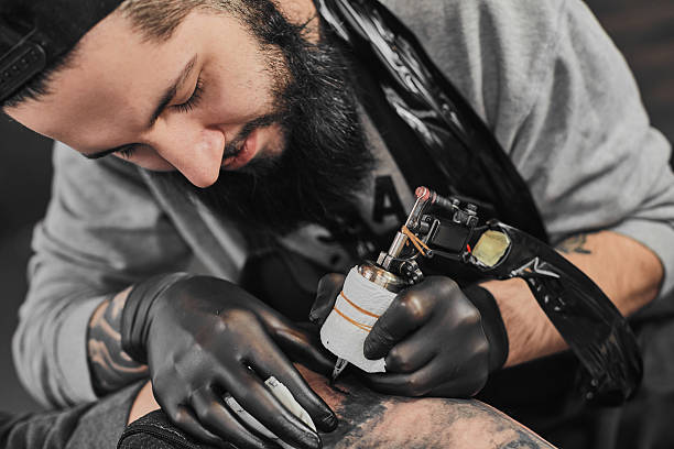 istock Tattoo master is tattooing in the tattoosalon 636373280