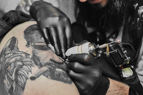 istock Tattoo master is tattooing in the tattoosalon 636373762