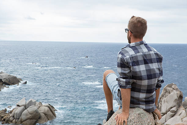 istock One young man relaxing by the sea 636377054