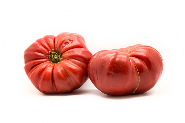 istock Two homegrown heirloom tomatoes  isolated on white 636377356