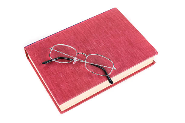 istock Book with reading glasses isolated on white background 636380624