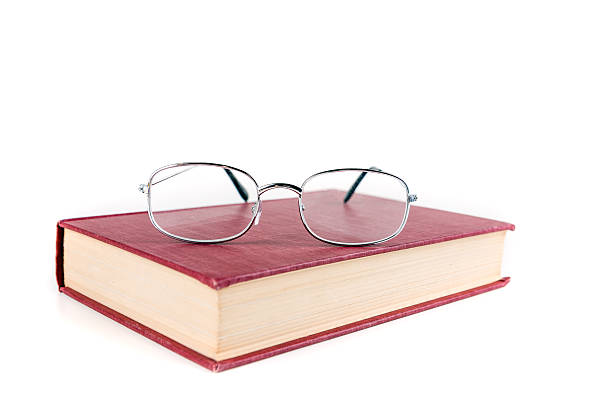 istock Book with reading glasses isolated on white background 636380670