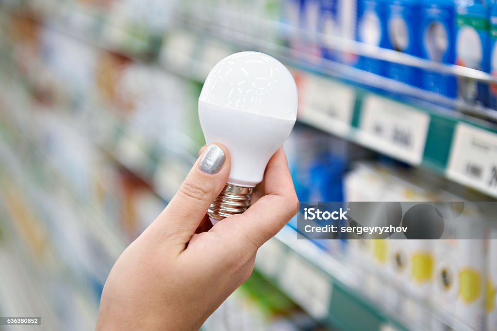 Energy saving LED lamp in hands of buyer at store Energy saving LED lamp in the hands of the buyer at the store Light Bulb Stock Photo