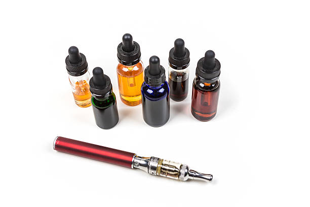 Assorted flavors of vape juice and an ecigarette Assorted flavors of vape juice and an ecigarette isolated on white background nonsmoker stock pictures, royalty-free photos & images