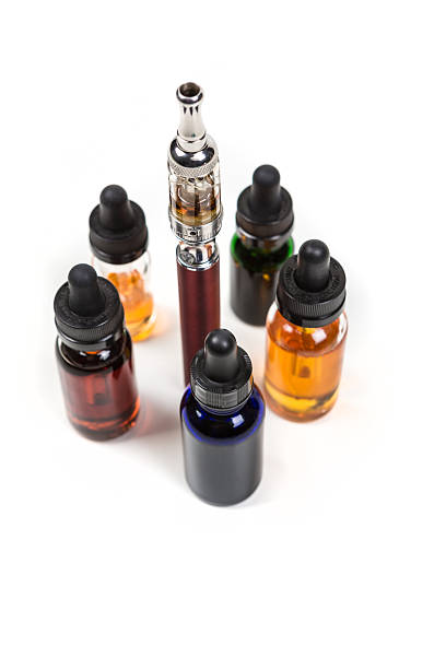 Assorted flavors of vape juice and an ecigarette Assorted flavors of vape juice and an ecigarette isolated on white background nonsmoker stock pictures, royalty-free photos & images