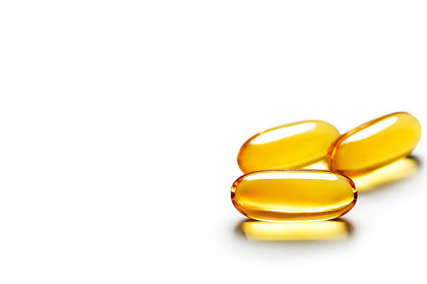 kapsułki wyizolowane na białym tle. - fish oil vitamin e cod liver oil nutritional supplement zdjęcia i obrazy z banku zdjęć