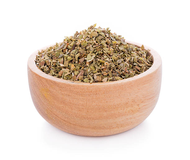 istock Dried Oregano on wooden bowl on white background 636391120