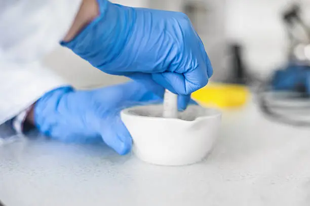 Chemist performs an experiment with liquid nitrogen in laboratory mortar with pestle