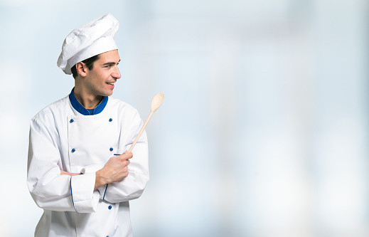 Portrait of a smiling chef in front of a bright background