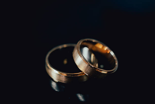 istock Beautiful wedding golden rings on dark background 636398996