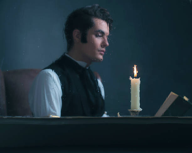 istock Candlelight behind rainy window with retro victorian man reading book. 636399930