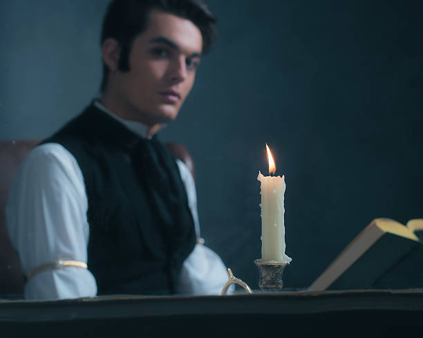 istock Candlelight by window with blurred retro victorian man reading book. 636400026