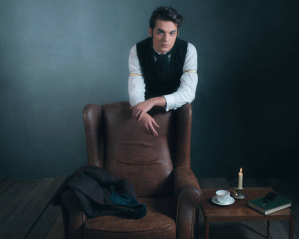 istock Retro victorian man leaning on back of leather chair. 636400440