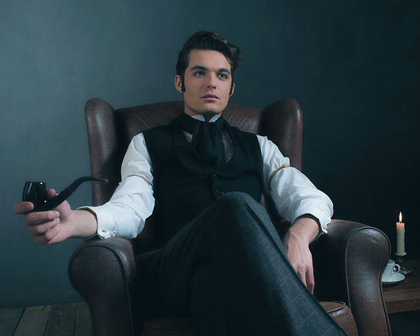 istock Retro victorian man sitting in leather chair holding pipe. 636400486