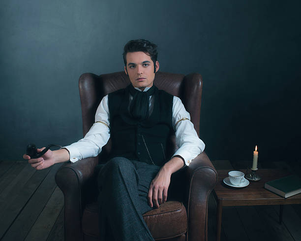 istock Retro victorian man sitting in leather chair holding pipe. 636400516