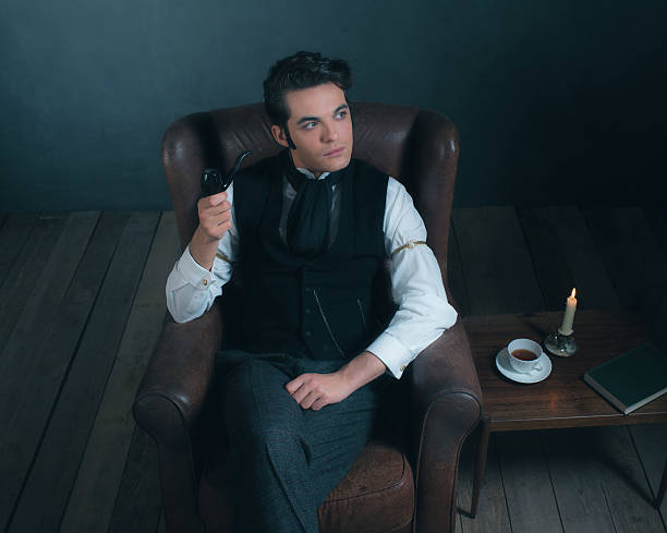 istock Retro victorian man sitting in leather chair holding pipe. 636400540