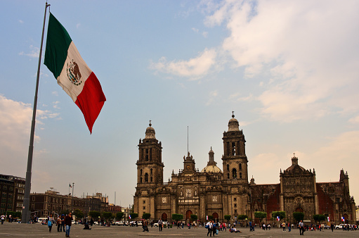 Mexico City, Mexico - November 14, 2016: Big Mexican Flag on Zocalo near Cathedral - Mexico City, Mexico