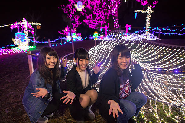 istock Three young girls posing in Christmas lights 636401396