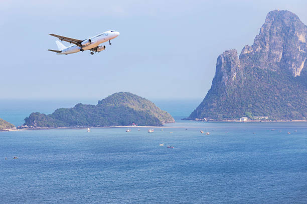 istock airplane landing above small island in blue sea 636406494