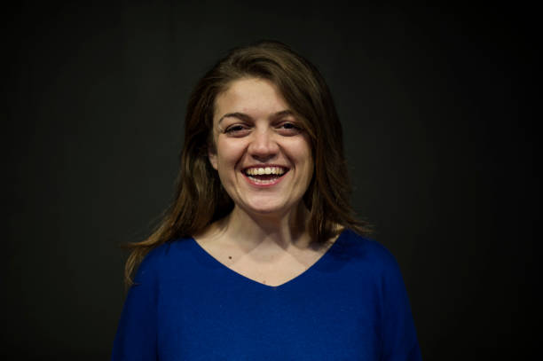 istock Cheerful Young Woman Posing Front of a Black Wall 636413240