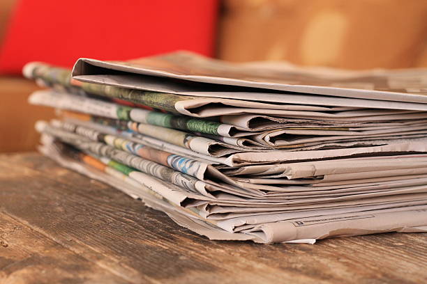 istock Newspapers on wooden table 636415164