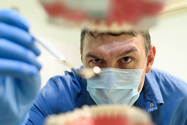 istock Dentist showing a model of teeth 636415428