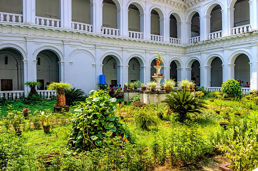 Patio with tropical plants in pots in the famous landmark - Basilica of Bom Jesus or Borea Jezuchi Bajilika. Basilica - UNESCO World Heritage Site and functioning church.