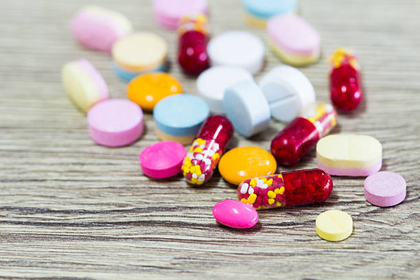 istock Colorful pills over wooden background 636419768