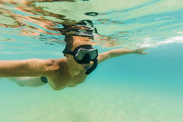 istock Man Snorkeling in Clear Turquoise Water 636420324