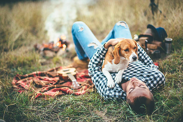 Man enjoying with his dog near campfire