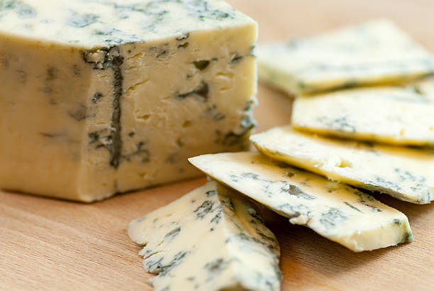 istock tasty sliced moldy cheese on wooden plate 636423792