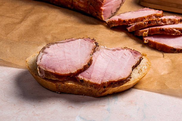 istock Slices smoked meat or ham on brown packing paper. 636424030