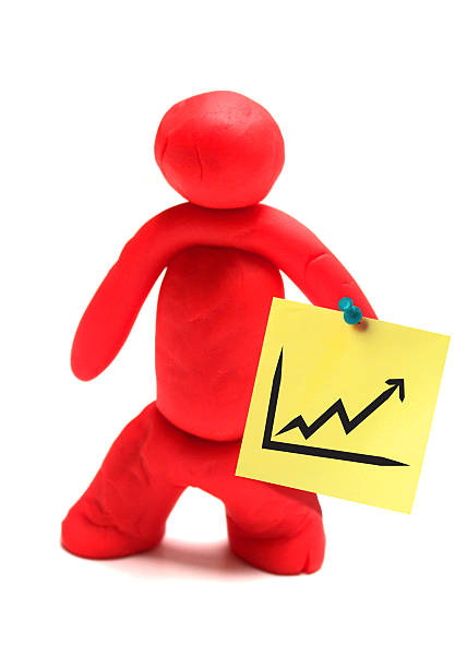 Rising Values Colored doll is showing success graphic board on white background. man writing on white board stock pictures, royalty-free photos & images