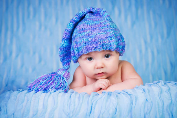 Newborn in knitted cap on a blue background. stock photo