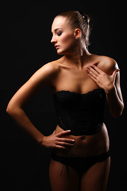 Beautiful sexual young woman in black lingerie in studio